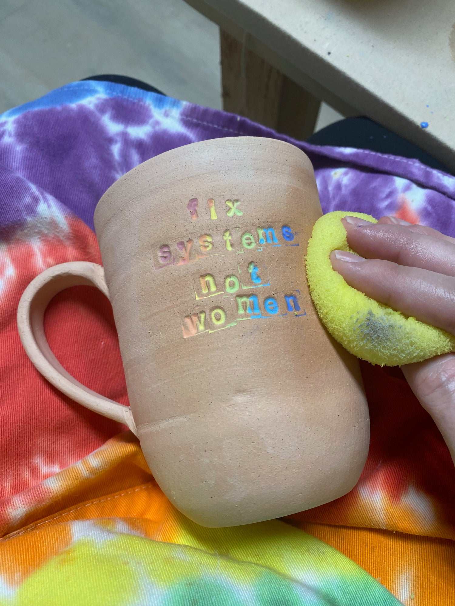 sponging mug over tie dye apron