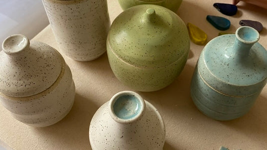 white, light blue, and light green lidded jars seen from above