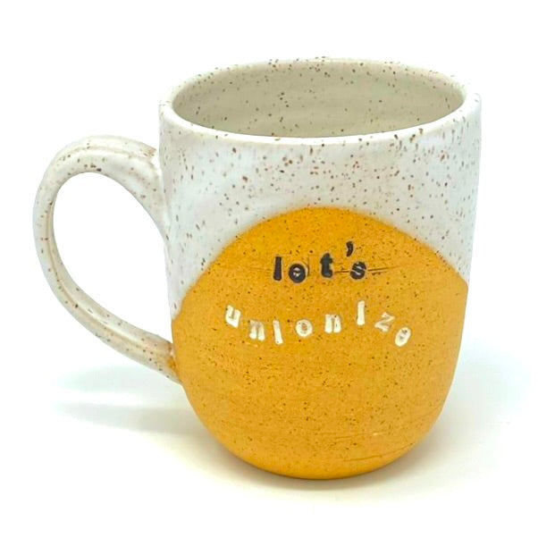 a mug with the words "let's unionize" stamped on the front, with white glaze inside, on rim and handle.